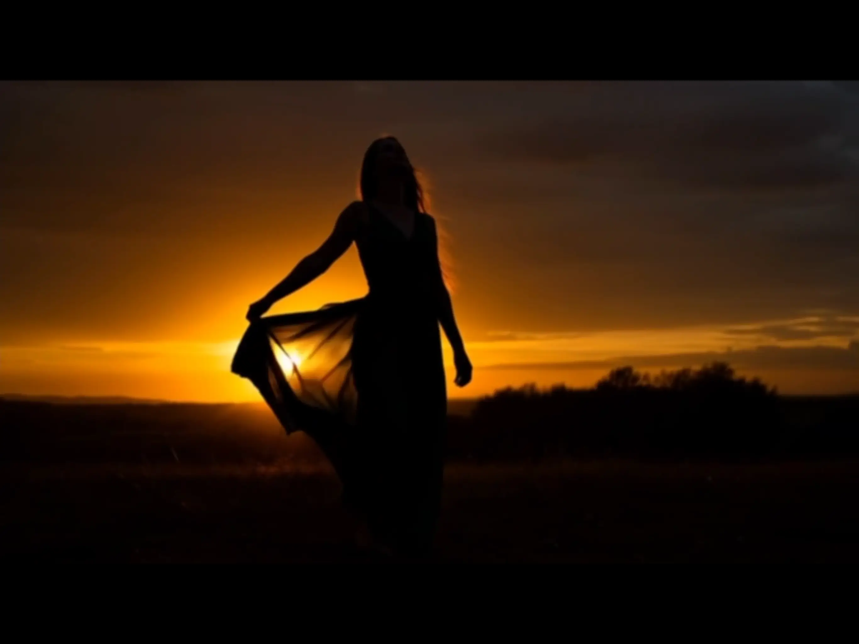 Cinematic figure dancing at sunset.